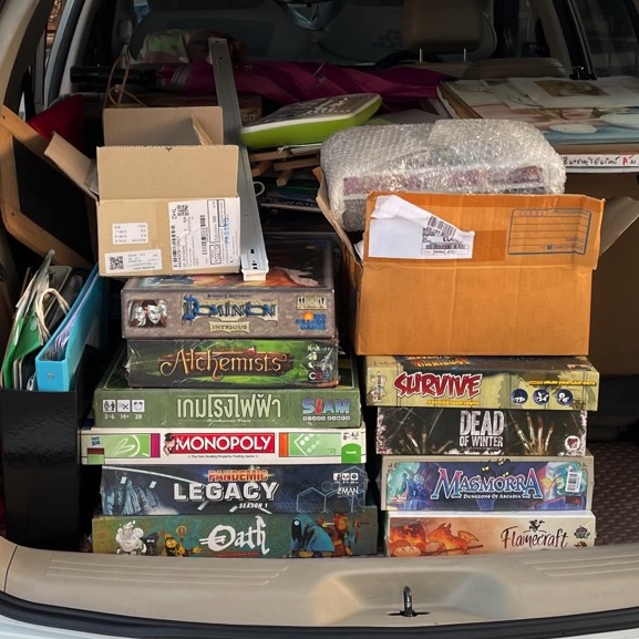 Back of a suv with boxes of boardgame stack on top of each others